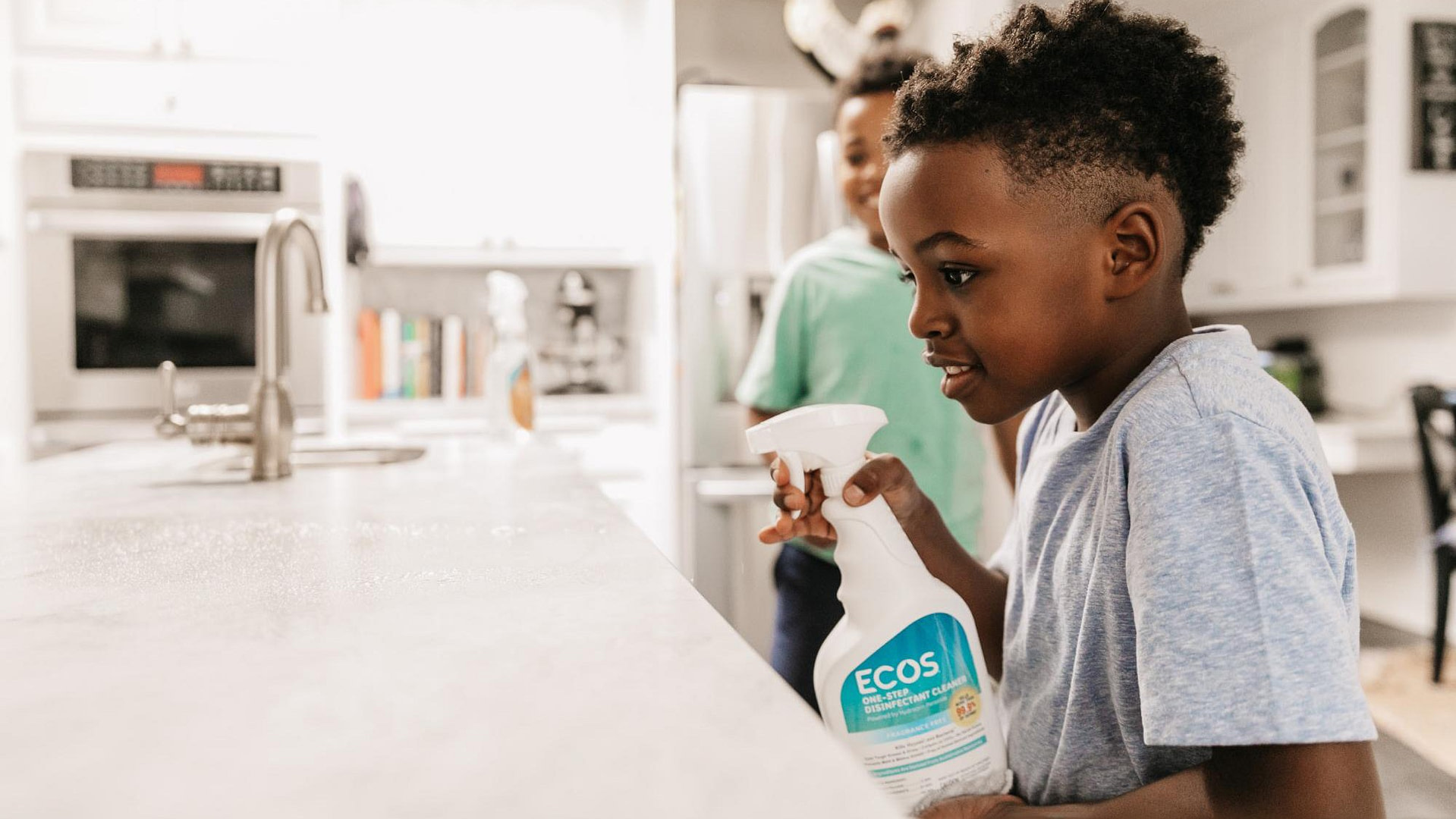 Children Using Fragrance Free Disinfectant Spray To Clean Counter